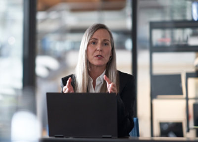 A woman sitting at a table with a laptop.