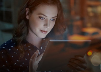 Closeup of a woman smiling and working on the laptop