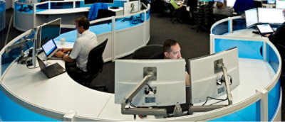 A man sitting at a desk using a laptop.